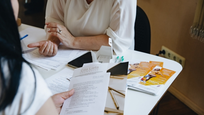 Cilvēki pie galda sarunājas