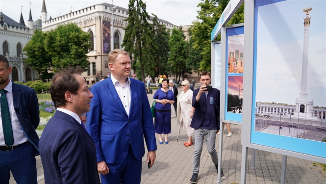 Rīgas domes priekšsēdētāja vietnieks Edvards Smiltēns un pilnvarotais Kazahstānas Republikas vēstnieks Latvijā Timurs Primbetovs Līvu laukumā atklāj fotoizstādi par Kazahstānas galvaspilsētu Nursultanu