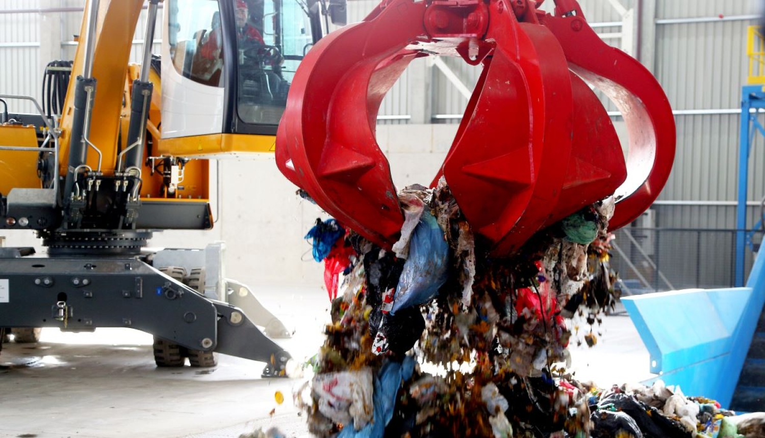 Ceļamkrāns izkrauj atkritumus