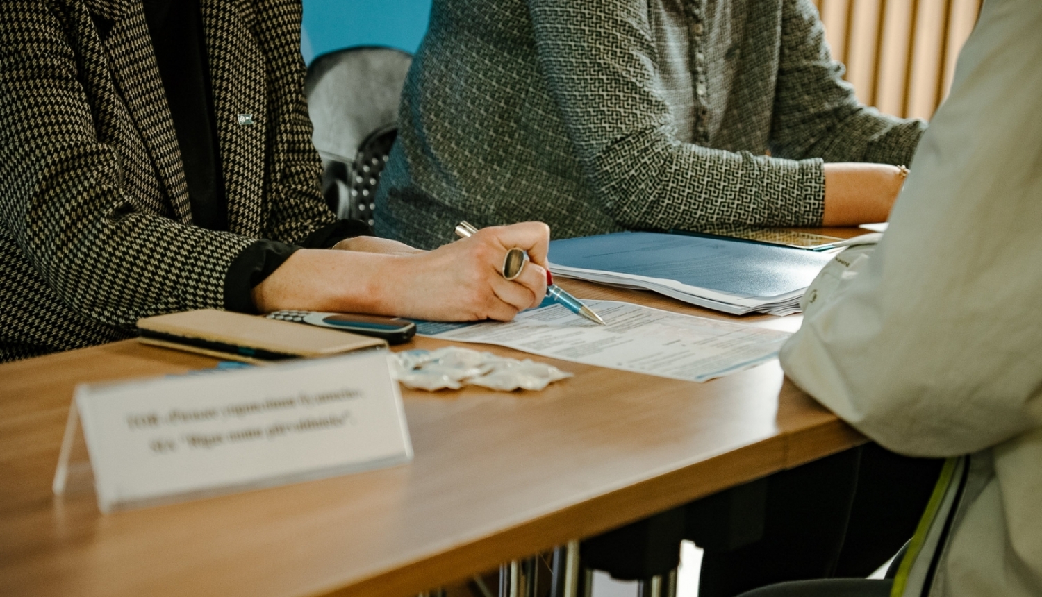 Cilvēki sēž pie galda