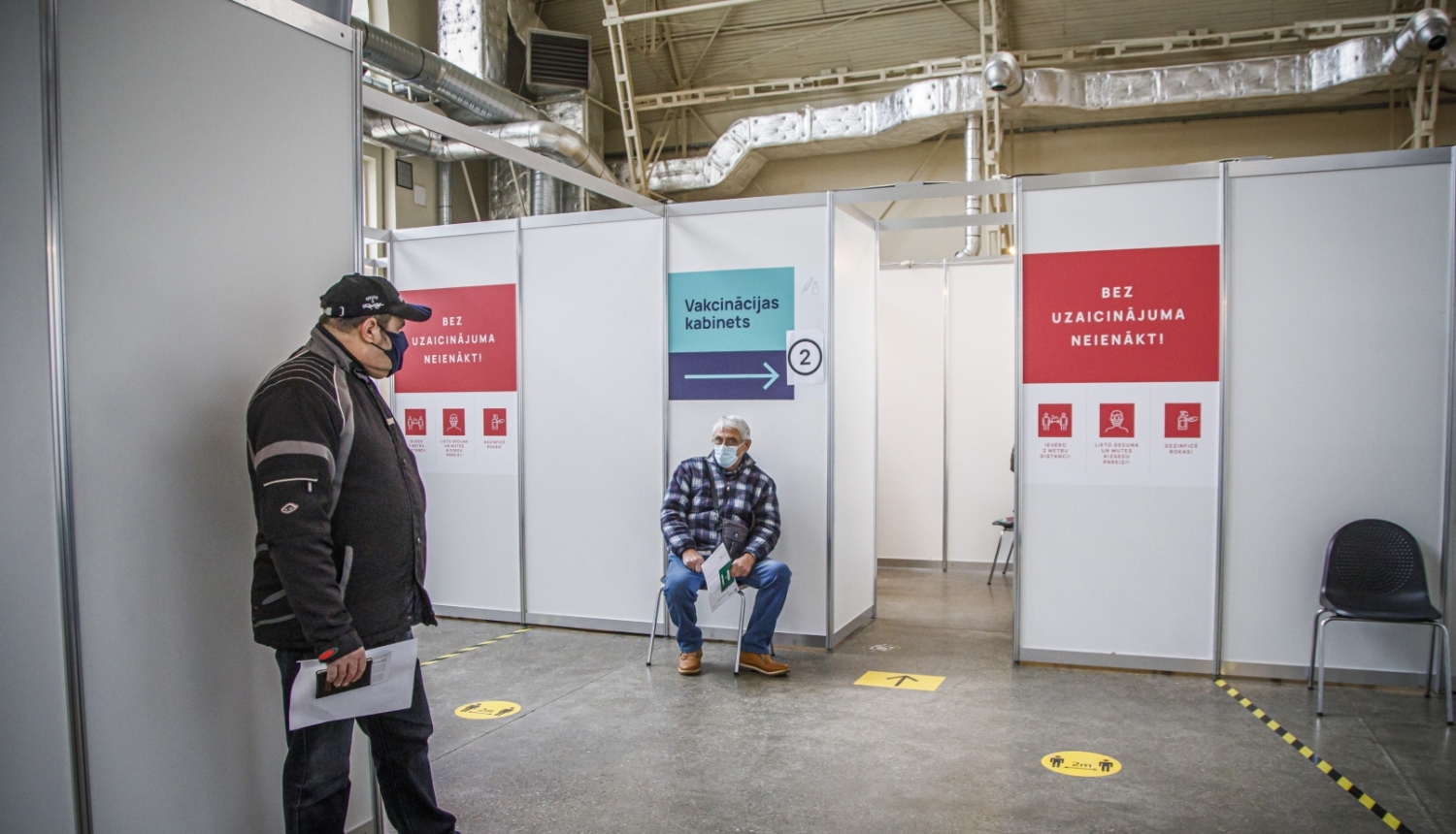 Cilvēki gaidā rindā uz vakcīnu 