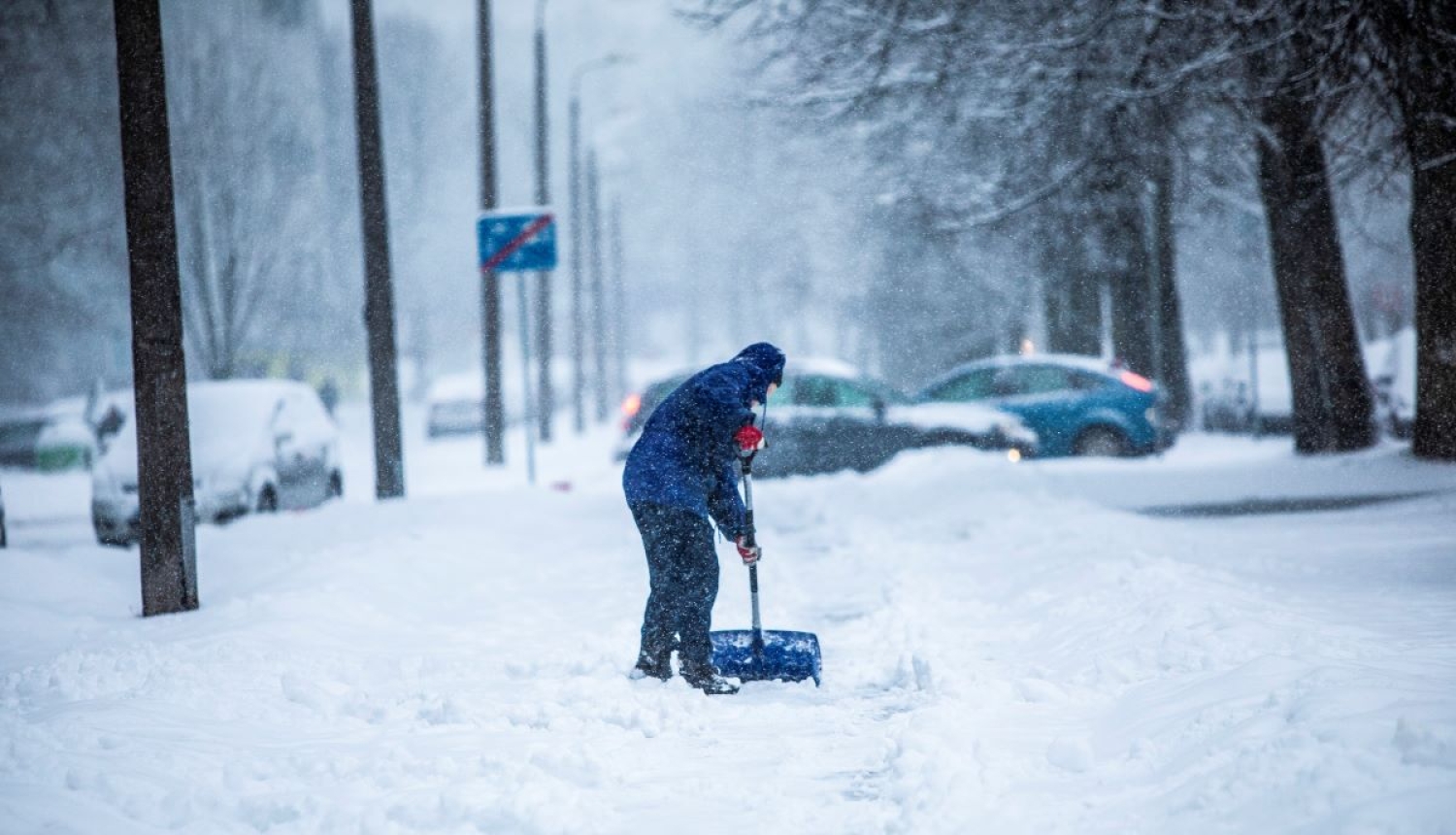 Cilvēks tīra sniegu