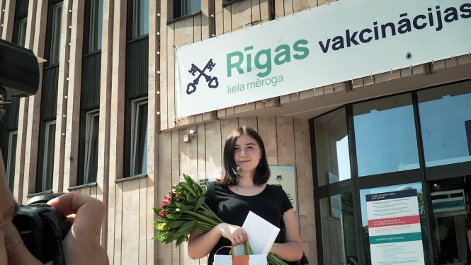 Sieviete ar ziediem un balvu