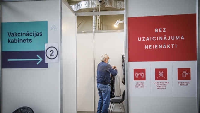 Cilvēki gaidā rindā uz vakcīnu 