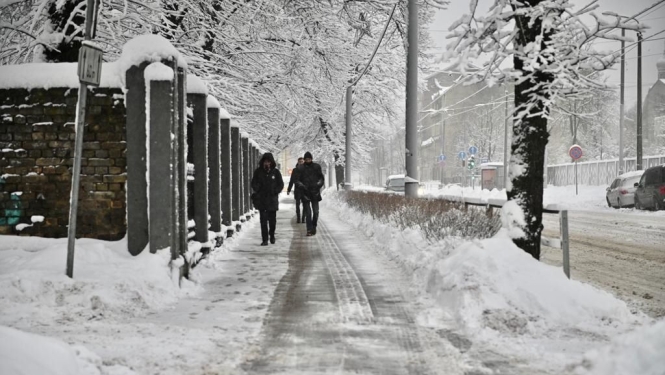 Cilvēki iet pa ielu ziemā