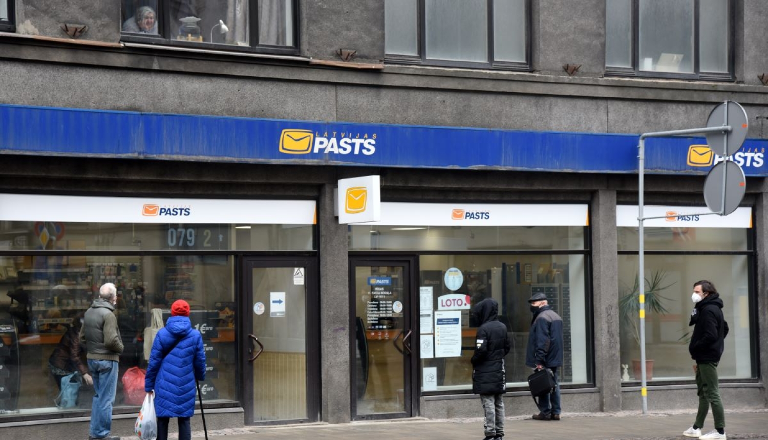 Cilvēki stāv rindā pie Latvijas pasta